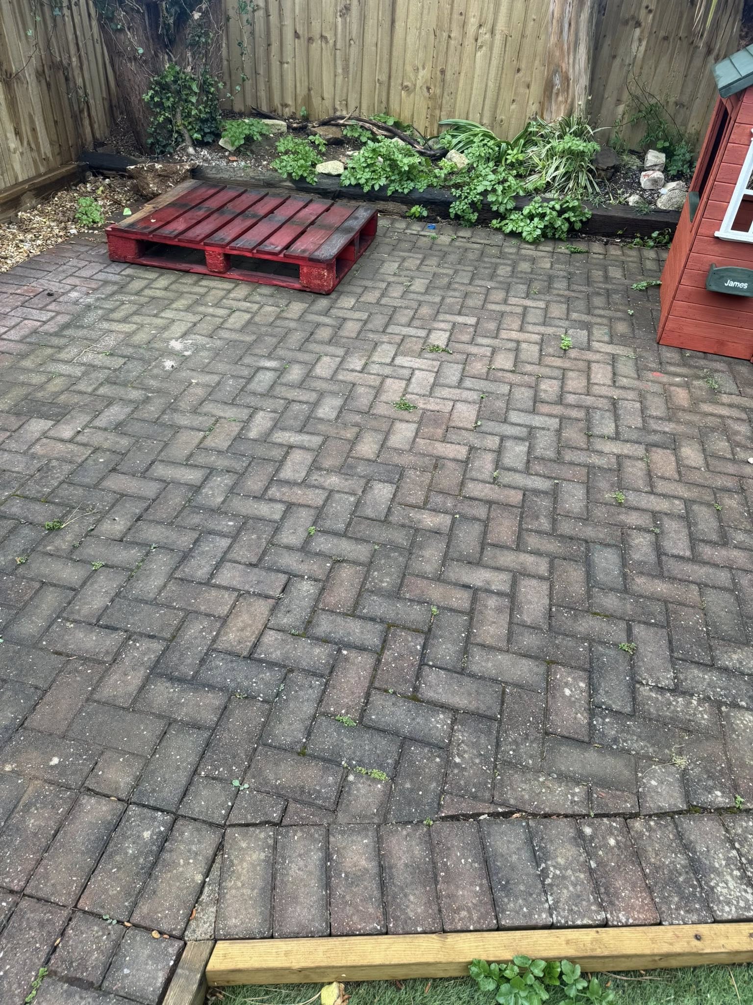 Block paved patio in a garden before pressure washing in Weymouth