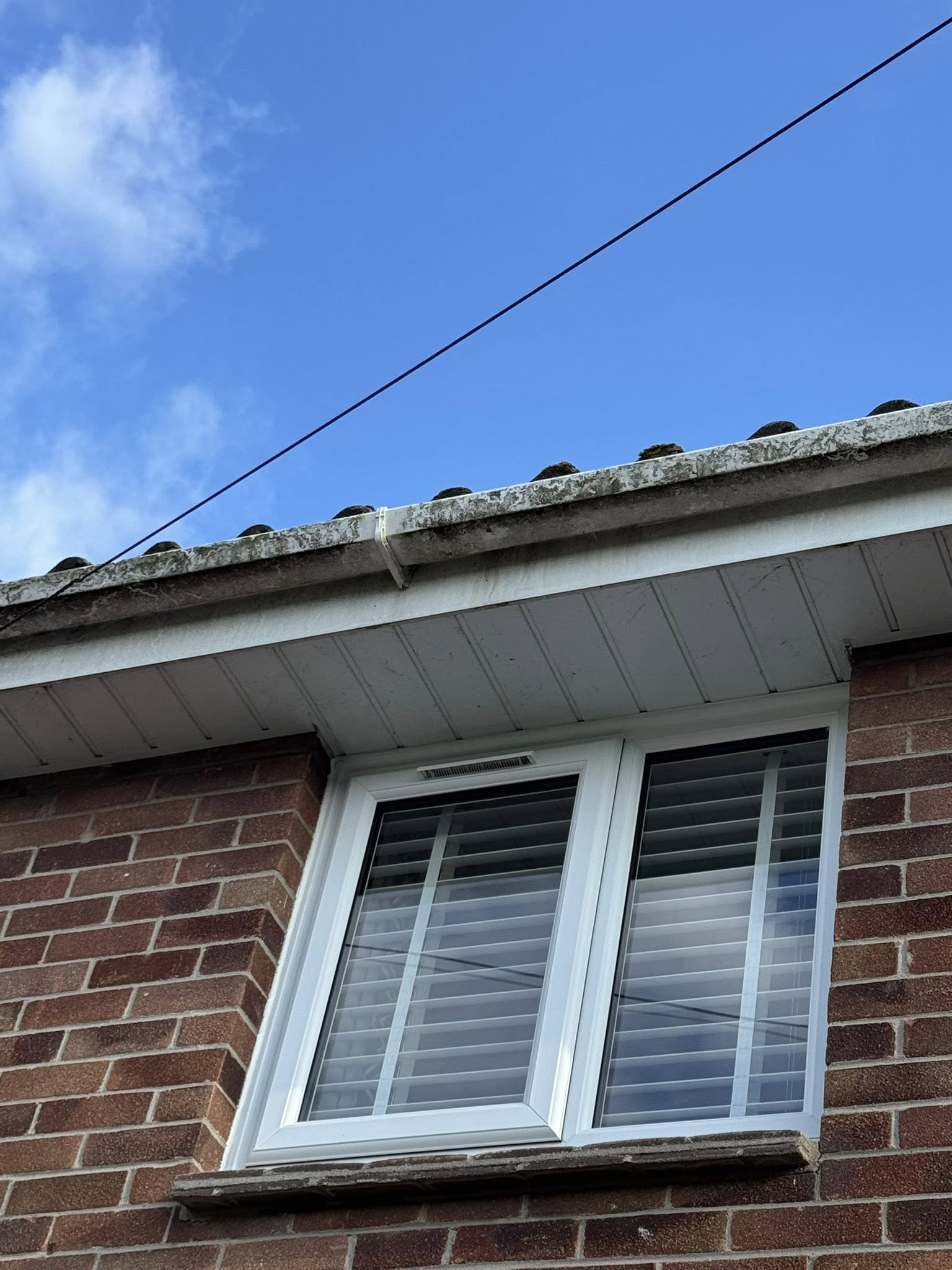 Dirty gutters on a house in Weymouth before pressure washing