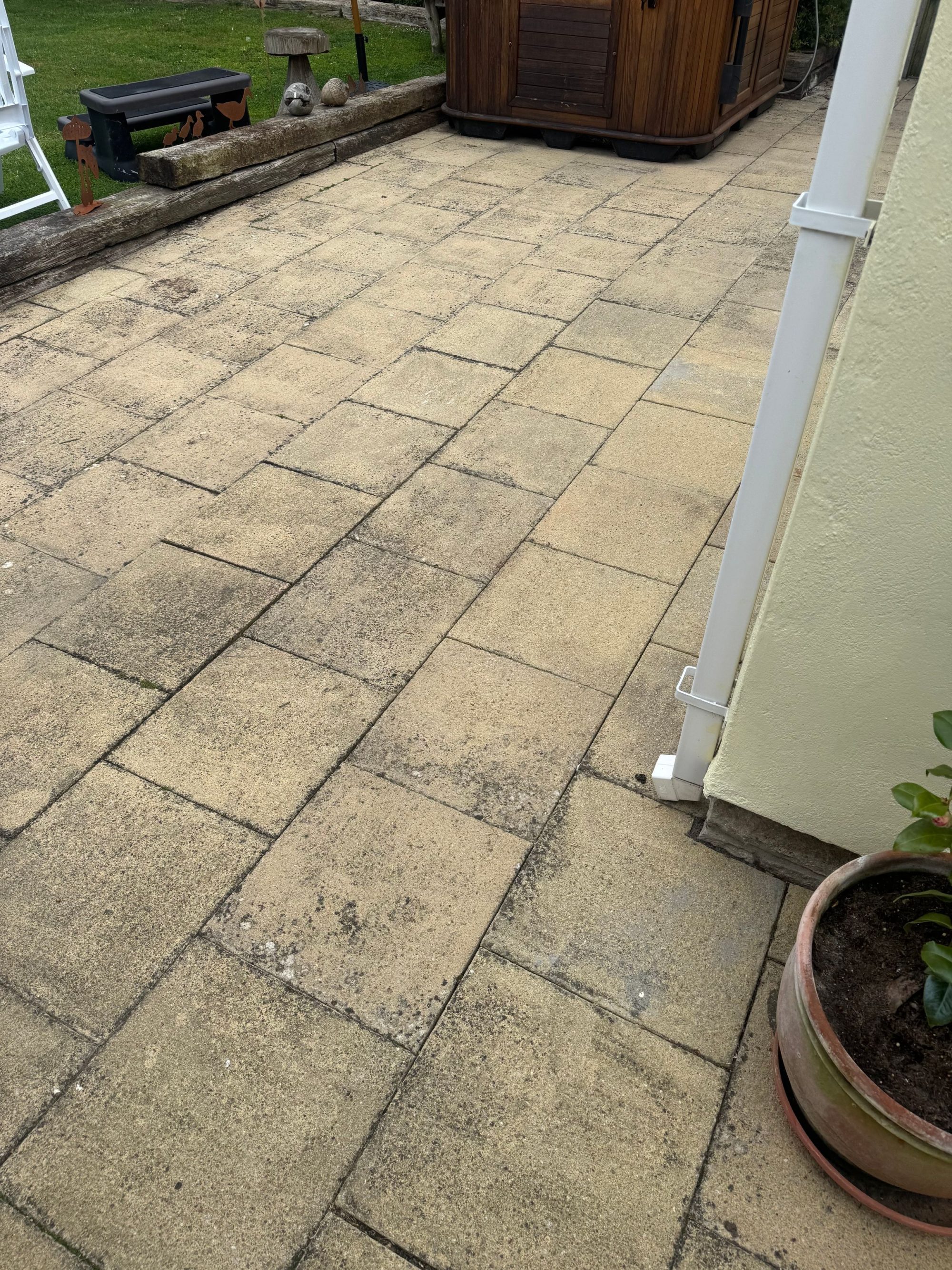 Paved patio area of a house before pressure washing in Weymouth